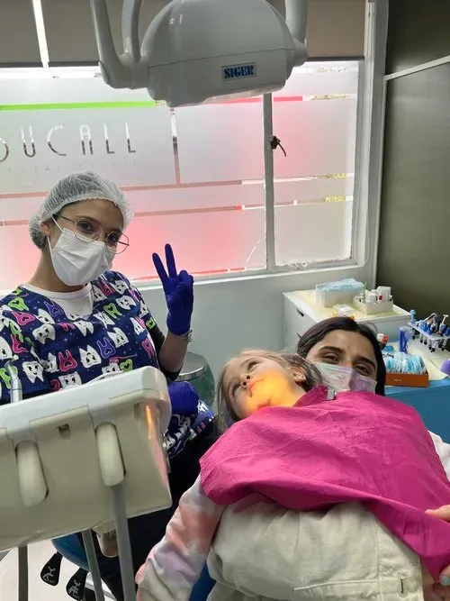 Niña tranquila en su atención dental junto a su mamá